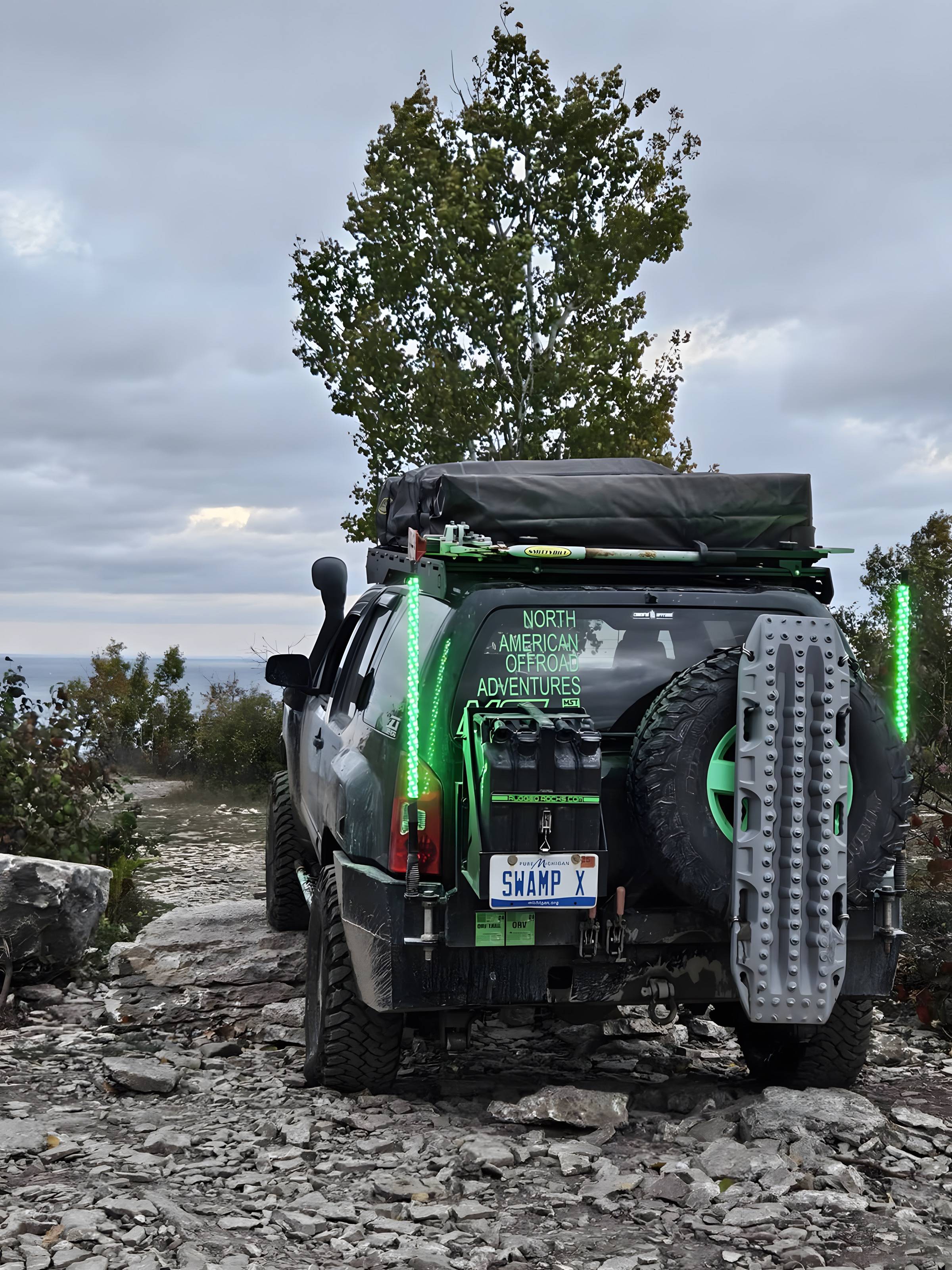 Expedition truck with rooftop tent parked on a rocky clifftop
