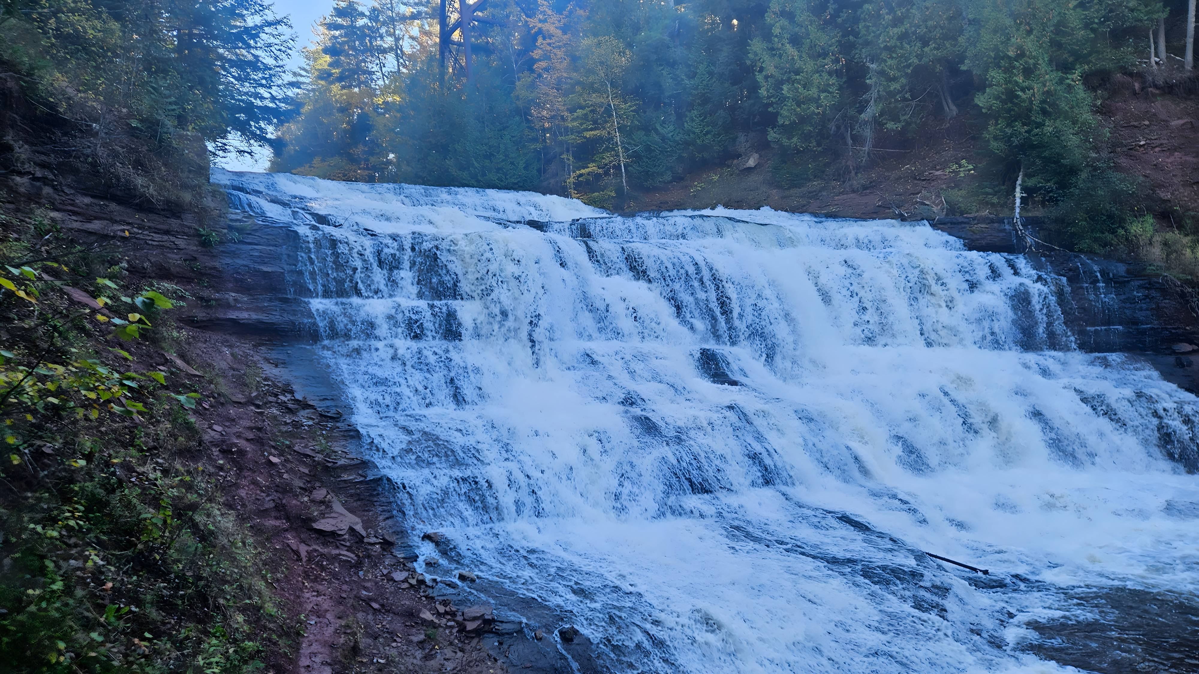 Wide tiered waterfall framed by forest